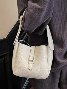 Beige lychee texture leather bucket bag with metal buckle and wide shoulder strap