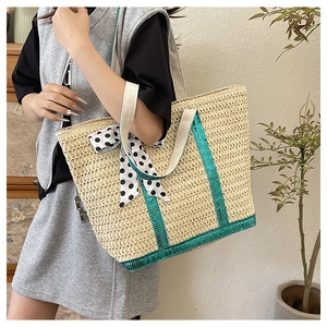 Détail du sac cabas en paille avec paillettes vertes et nœud à pois sur la poignée