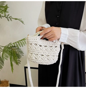 Detail of hand-woven white bucket bag featuring floral hollow knit patterns and sturdy strap