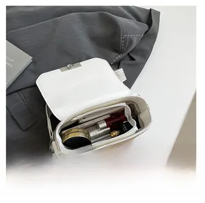 Interior view showing capacity of white crossbody bag with phone and cosmetics