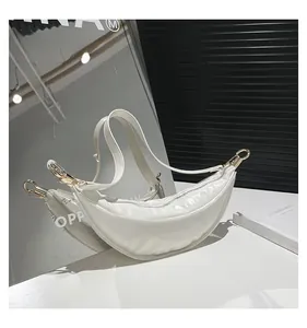 Detail of white glossy patent leather hobo bag with silver metallic ring buckles