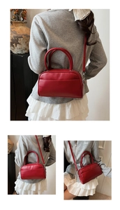Detail view of the red Boston style handbag with silver hardware and front pocket