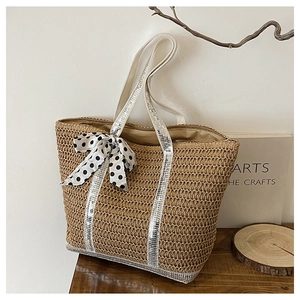 Détail du grand sac cabas en paille avec brides à paillettes et un nœud à pois