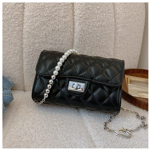Détail du sac matelassé noir avec poignée en perles et bandoulière chaîne argentée