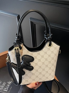 Sac seau élégant à motifs géométriques avec breloque chiot dans un décor lifestyle