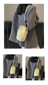 Détail du sac seau en cuir ciré jaune avec cordon de serrage et finitions argentées