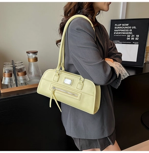 Détail du sac sous le bras en similicuir jaune clair élégant avec poche zippée avant