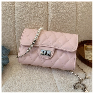 Détail du sac à bandoulière matelassé rose clair avec élégante chaîne en perles et métal