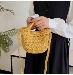 Detailed macro view of yellow hand-woven crochet bag with gold metal hardware and fabric lining