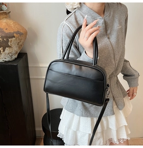 Detail view of black PU leather Boston bag with dual handles and adjustable shoulder strap