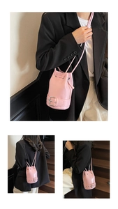 Vue détaillée du sac seau rose brillant avec fermeture à cordon et boucle décorative