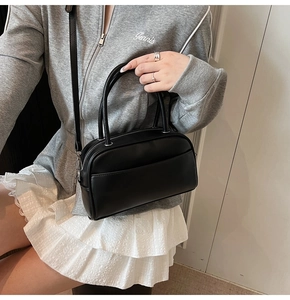 Detailed close-up of a black leather Boston bag with silver hardware and dual handles