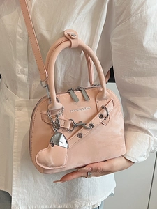 Sac coquillage en cuir mat rose avec chaîne argentée et breloque cœur sur mannequin