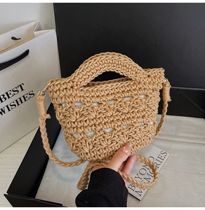 Detail of woven straw bag with gold hardware and fabric lining in a gift box setup