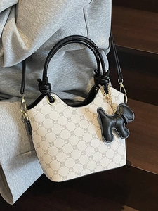Sac seau imprimé monogramme avec breloque chien et poignée noire en finition crème chic