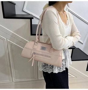 Sac à bandoulière rose minimaliste avec pompon zippé allongé et plaque logo métallique
