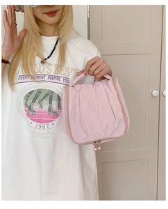 Detail of pink ruffled makeup bag featuring smooth dual zippers and beaded pullers