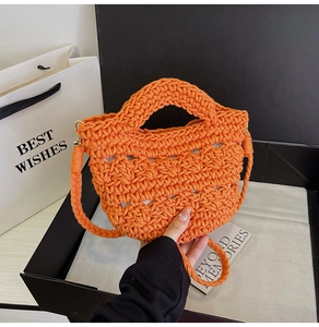 Detail of orange woven basket bag with integrated handle and gold buckle strap