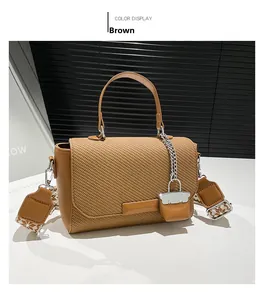 Detail view of brown crossbody bag featuring woven texture and jacquard strap