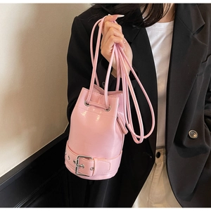 Sac seau en cuir ciré rose brillant avec sangle à boucle présenté sur un mannequin