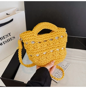 Detailed close-up of yellow hand-woven hollow knit bag with strap and interior lining
