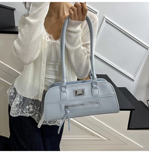 Détail du sac sous l'aisselle bleu clair avec garnitures argentées et longues tirettes