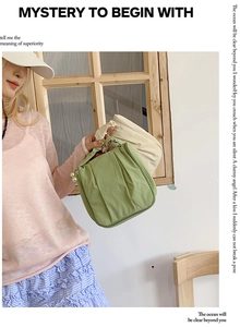 Detail of pleated fabric cosmetic bag with pearl zipper pull and portable top handle
