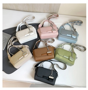 Flat lay of colorful textured crossbody bags with wide patterned ethnic straps in seven colors