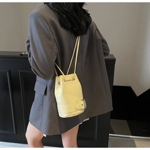 Détail du sac seau jaune vif en cuir ciré avec boucle argentée et cordon de serrage