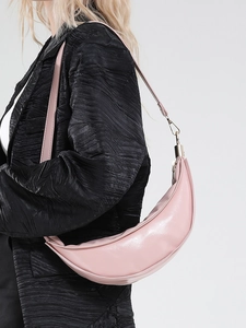 Elegante borsa a tracolla hobo rosa a mezza luna per donna indossata da una modella