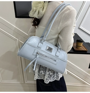 Détail du sac sous le bras en cuir PU bleu clair mat avec plaque en métal argenté et gland