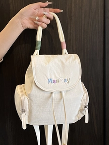Minimalist off-white mini backpack featuring colorful embroidery and drawstring closure