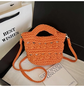 Detailed macro view of orange woven handbag featuring intricate texture and golden hardware