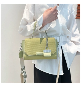 Detail of avocado green crossbody bag featuring woven texture and geometric wide strap