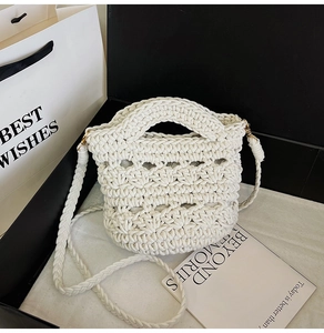 Close-up of cream woven handbag showing honeycomb texture and gold metal hardware