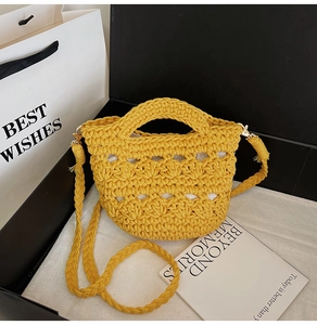 Detail of yellow woven bucket bag featuring intricate cutout patterns and beige fabric liner