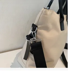 Détail du sac cabas beige avec boucle en métal argenté poli et large bandoulière noire