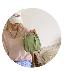 Close-up of pleated PU handbags in green and off-white with elegant pearl charm detail