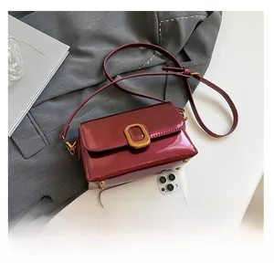 Vue détaillée du sac en cuir verni bordeaux avec fermoir doré vintage et référence de taille