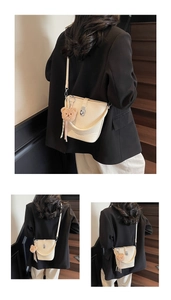 Detail of off-white bucket bag with lychee texture and brown teddy bear charm