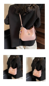 Close-up of pink leather shoulder bag with silver G logo and colorful beaded tassel detail