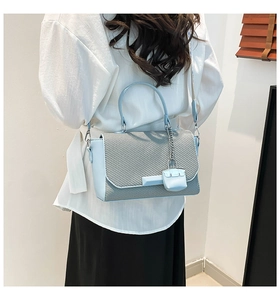 Detail view of woven pattern on a light blue and grey crossbody bag with mini pouch