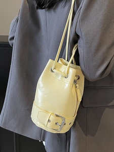 Sac seau minimaliste en cuir jaune clair avec boucle argentée et cordons serrage