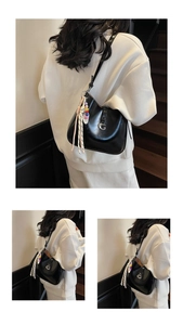 Detail of glossy black hobo shoulder bag with metal G buckle and colorful bead charms
