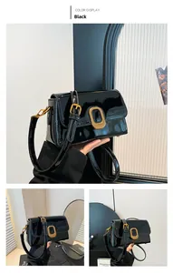 Détail du sac bandoulière en cuir verni noir avec boucle dorée de style vintage