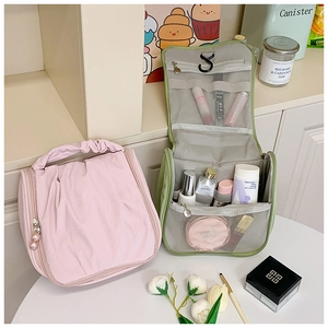 Detail showing internal compartments with hanging hook and pearl zipper of travel makeup bag