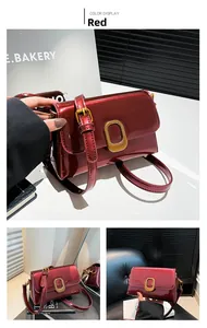 Détail d'un sac en cuir verni rouge avec fermoir métallique ovale doré de style vintage