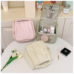 Detail of travel toiletry bags with pearl zippers, hooks, and multi-layer mesh compartments
