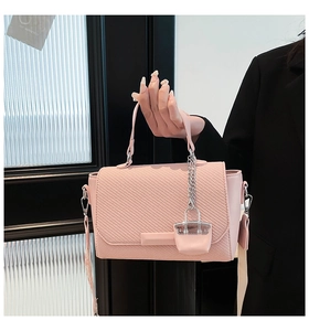 Detail of pink woven texture handbag with silver chain and wide fabric strap