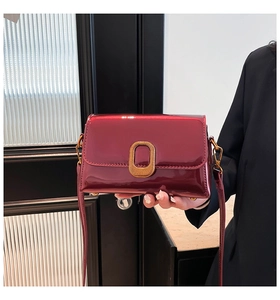 Vue détaillée du sac en cuir verni rouge foncé avec finition brillante et fermoir doré